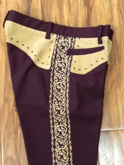 PANTALONES DE CHARRO. AUTHENTIC CHARRO PANTS THAT ARE DARK WINE WITH LIGHT BROWN SUEDE LEATHER STITCHED STENCIL ART WORK
